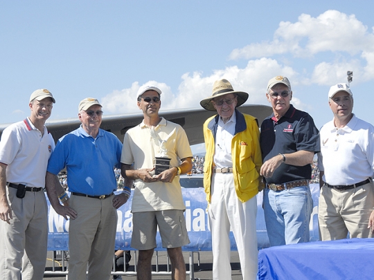 Photo By Lynn Krogh. Steve Marini receives the NAHF People’s Choice Award for his 1937 Spartan Executive 7W. L to R: Ron Kaplan, Neil Armstrong, Marini, Bob Hoover, Dick Rutan and Ken Perich. Via Airport Journals